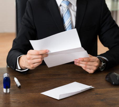Man in a suit holding a document